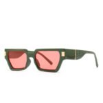Green rectangular sunglasses with thick frame, gold accents, textured temples, and red tinted lenses on white background