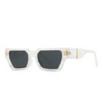 Transparent rectangular sunglasses with thick frame, gold accents, textured temples, and dark lenses on white background
