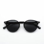 Round black sunglasses with matte black frame and dark lenses, unisex minimalist design